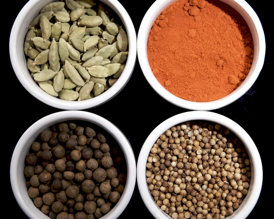 Green cardamom, chilli powder, black pepper and coriander seed in sample bowls